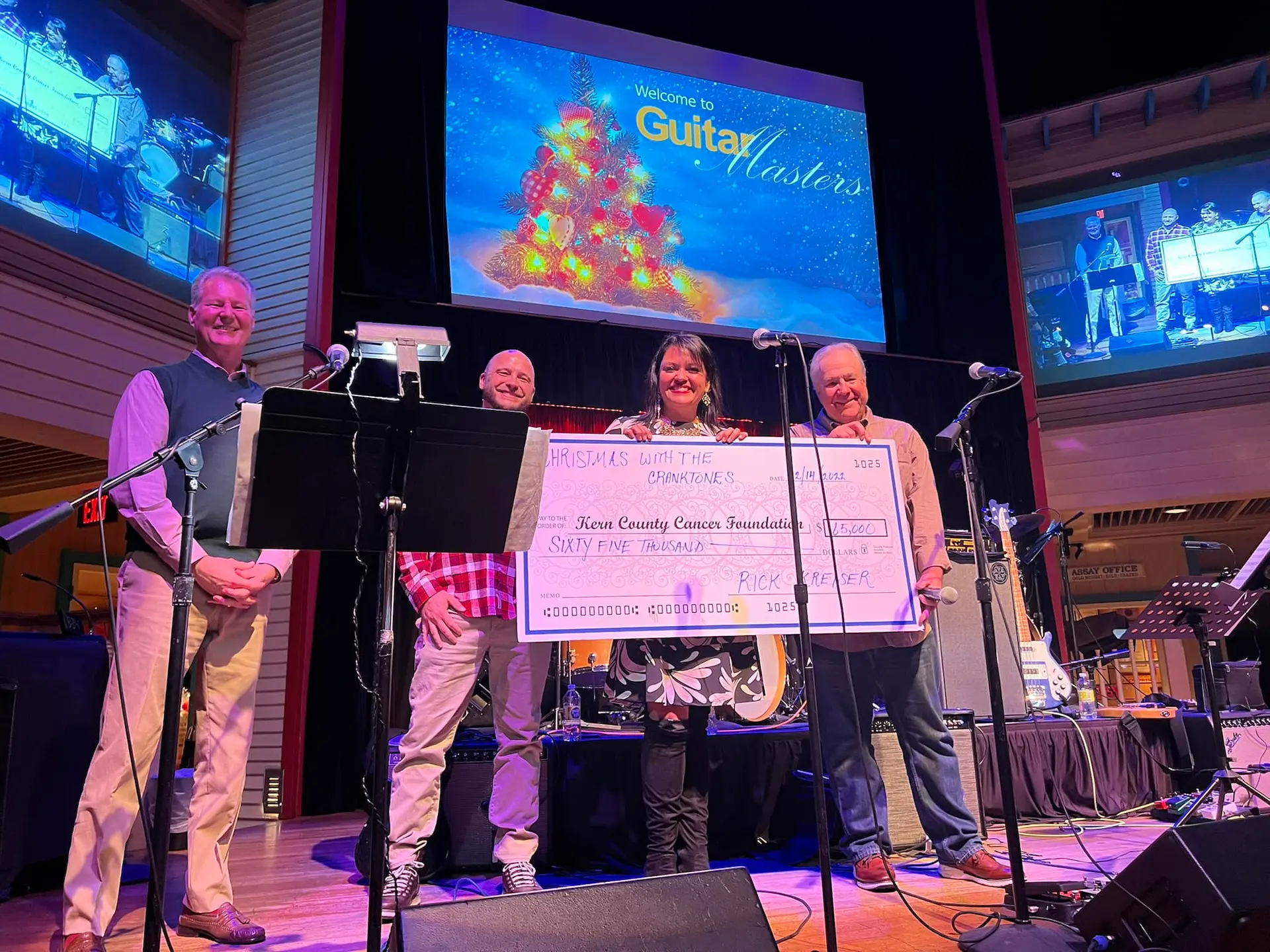 Christmas with The Cranktones presenting a check to KCCF president Michelle Avila on stage at Buck Owens' Crystal Palace