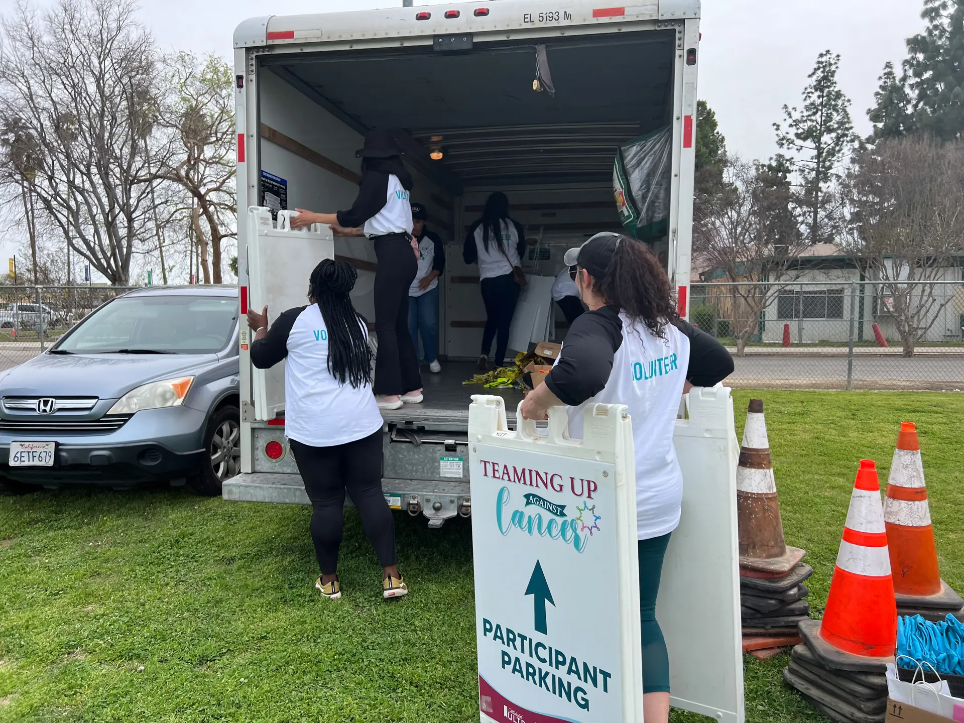 Teaming Up Against Cancer volunteers unloading signage from a moving truck
