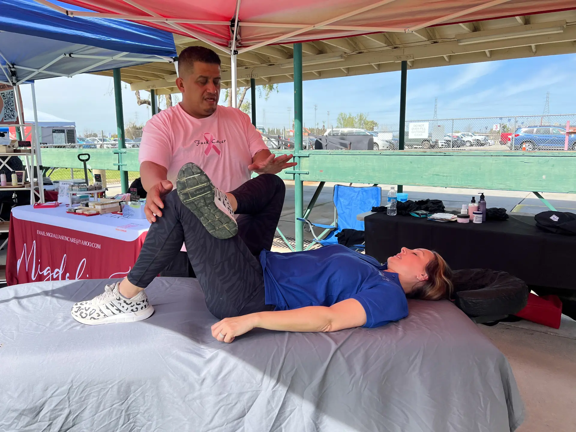 A member of the Kern County Cancer Foundation getting a chiropractic adjustment on a bed at Teaming Up Against Cancer 2023