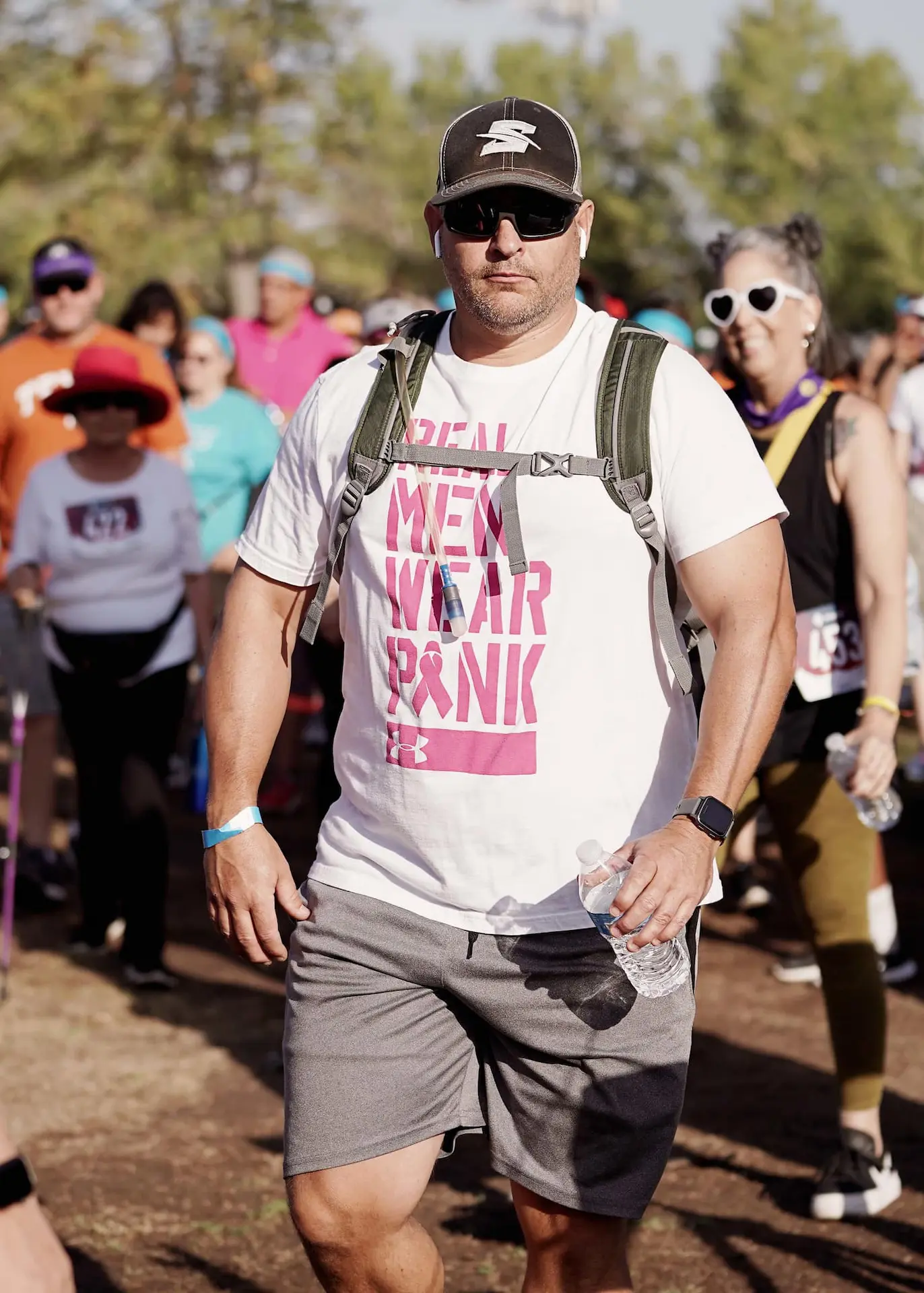 A man wearing a backpack and a real men wear pink shirt as he participates in Kern Run Walk