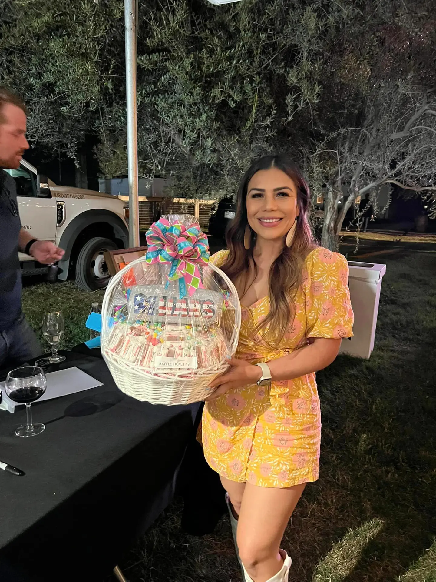 A woman holding a raffle ticket gift basket at Dust Bowl to Diamonds
