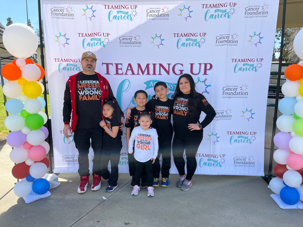 Madelyn Martinez and her family posing at Teaming Up Against Cancer event